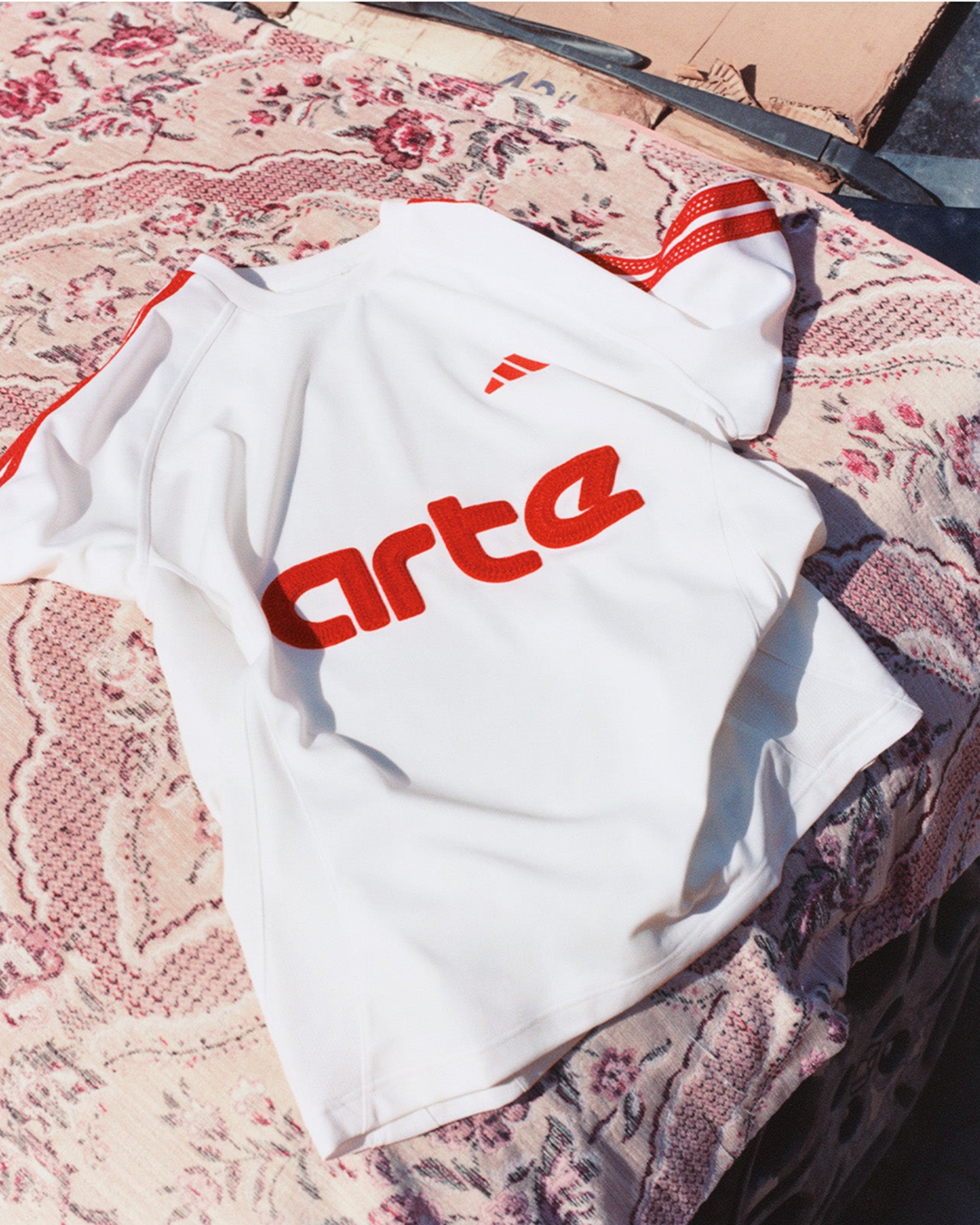 Joueurs portant la collaboration Adidas x Arte Antwerp sur un terrain de football à Marrakech, entre maillots graphiques et tracksuits streetwear.